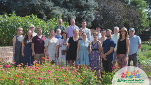 Applewood Seed employee owners stand in the trial gardens behind a full stand of colorful zinnias