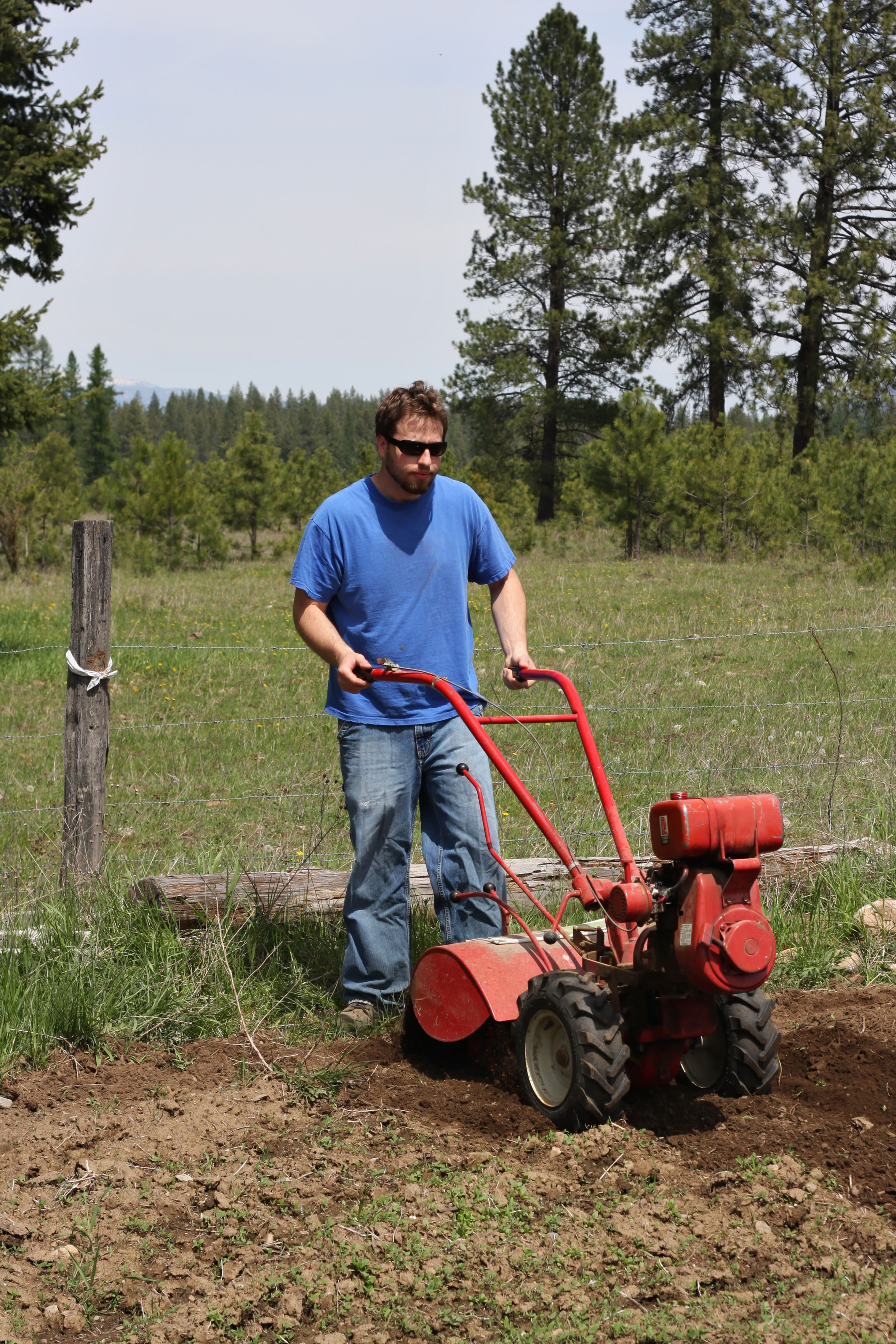 Man rototilling the ground, getting it ready for a garden. Applewood